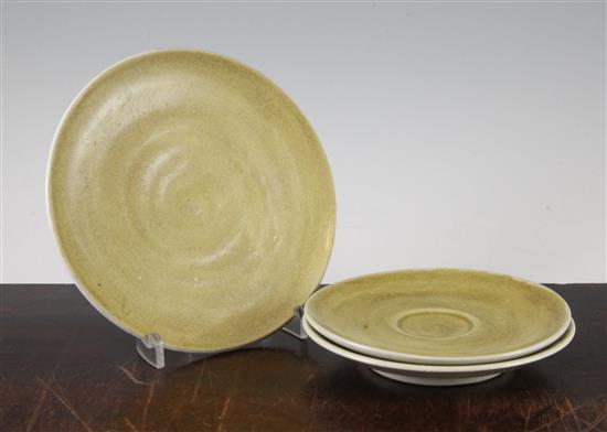 Dame Lucie Rie. A mustard glazed pottery plate and two matching saucers, 18.2cm and 15.2cm